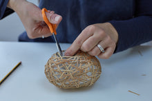 Load image into Gallery viewer, The process of making a weave basket, cutting the ends of the lapping cane.
