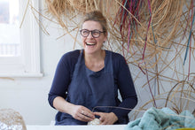 Load image into Gallery viewer, Maker Julia Clarke in her studio, surrounded by natural materials such as lapping cane and willow.
