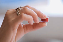 Load image into Gallery viewer, Close-up of hand holding a bobbin.
