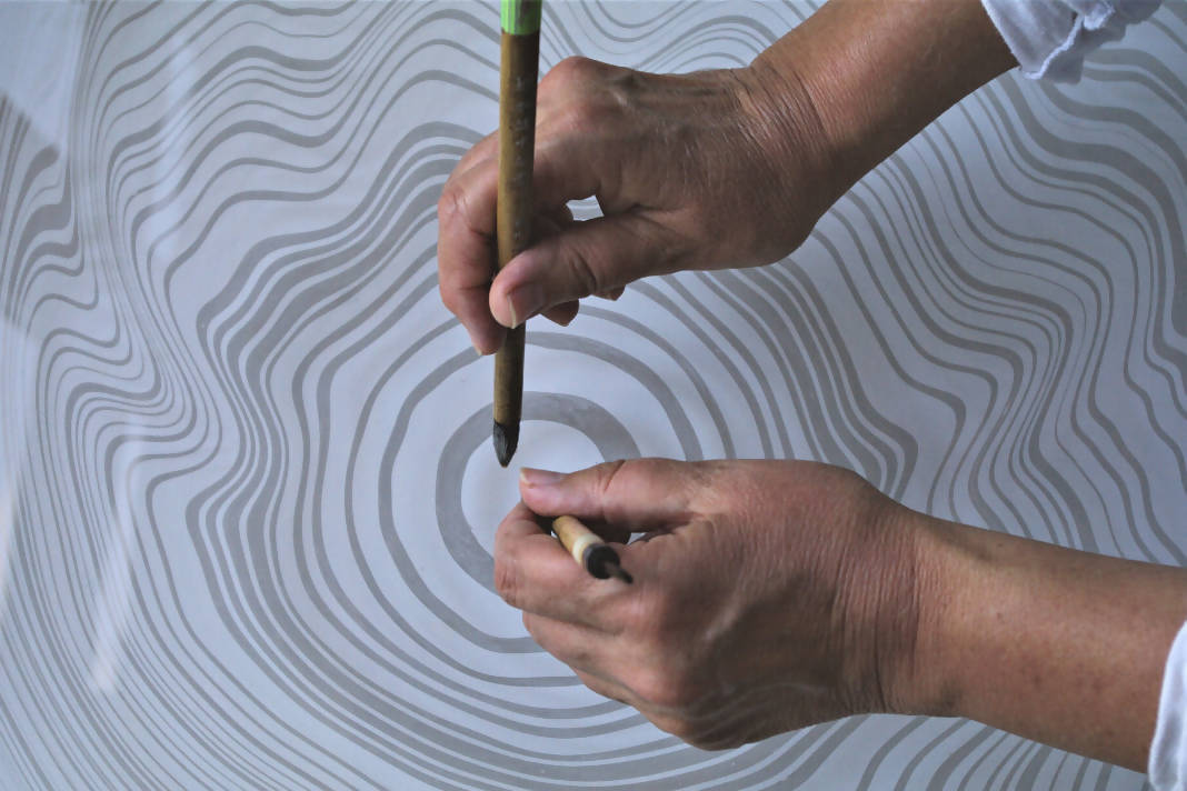 Floating ink on water to make suminagashi patterns.